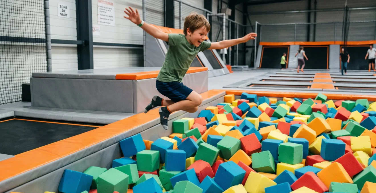 Enfant sautant dans une fosse remplie de cubes de mousse colorés dans un trampoline park